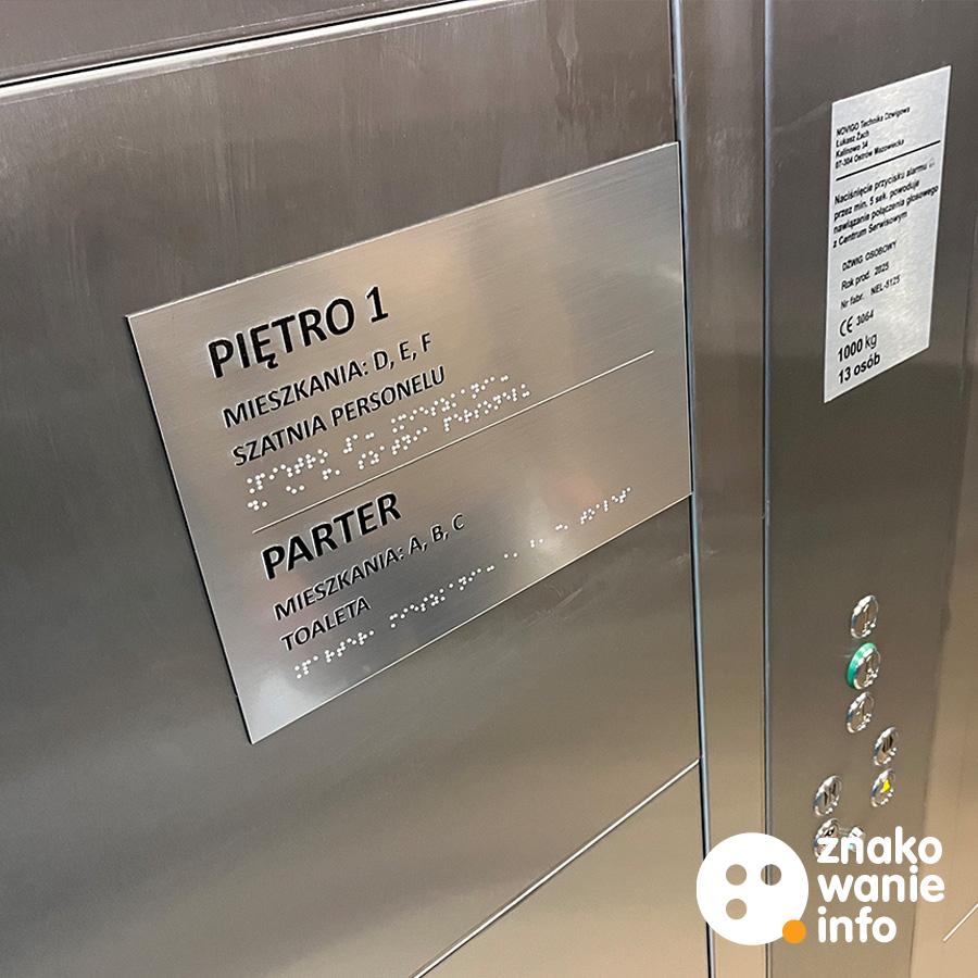 Tabliczka tyflograficzna w windzie ze srebrnego laminatu Tabliczka tyflograficzna w windzie ze srebrnego laminatu